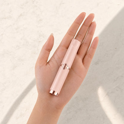 Pink Lumivea heated lash curler resting in a hand